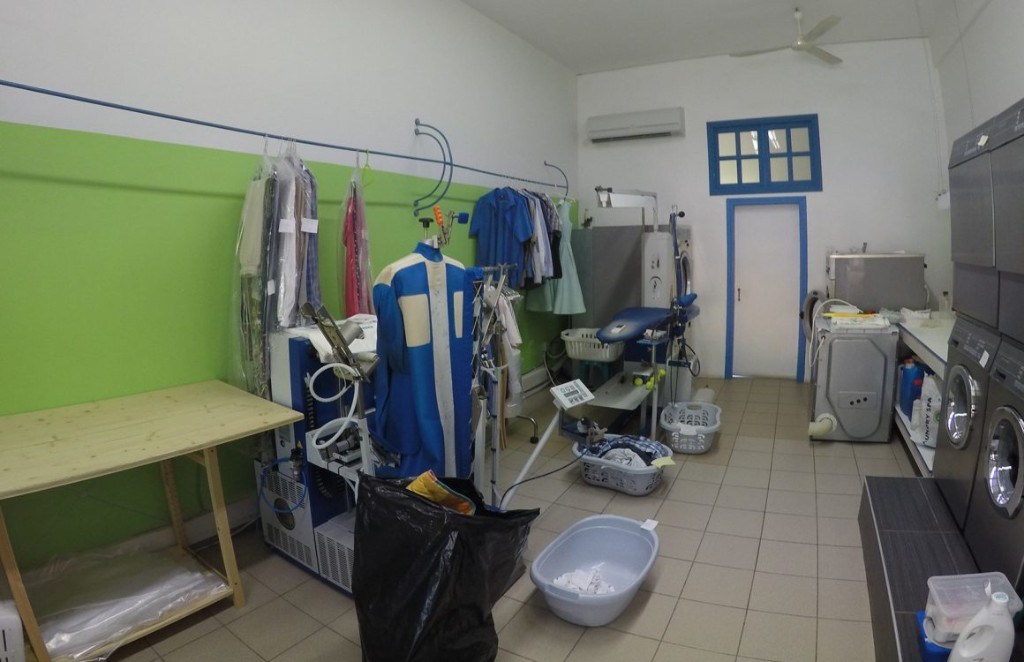 Eco Cleaners laundry shop interior with commercial washing machines in Kamari, Santorini
